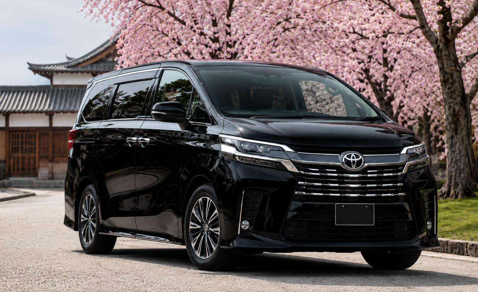 Under pink cherry blossoms, a black Toyota luxury minivan stands beside a traditional Kyoto building along a quiet paved lane in spring sunshine.