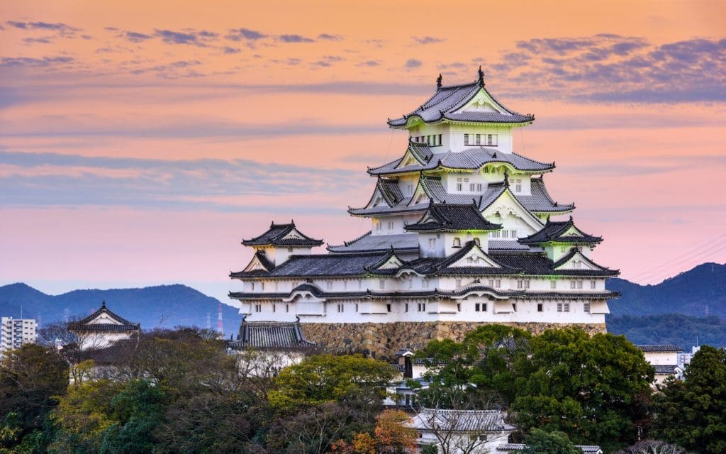 Hijime Castle with distinct architectural features against a colorful dusk sky, showcasing traditional Japanese design elements.