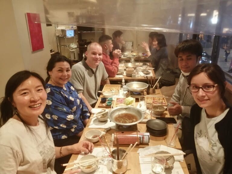 whatsapp-image-2025-06-29-at-06-49-12_126e9387 Group of six people dining together at a restaurant table with various dishes and utensils.
