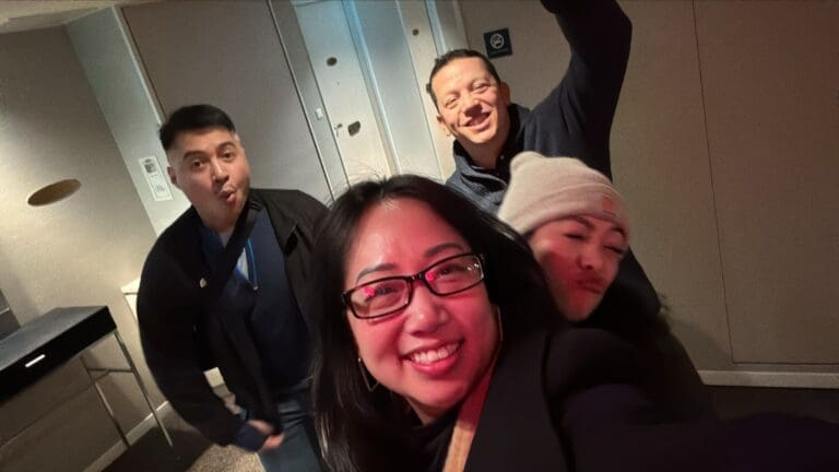 whatsapp-image-2025-07-15-at-10-26-48-am-2 Group of four individuals posing for a selfie in a hallway, with varied expressions and casual attire.