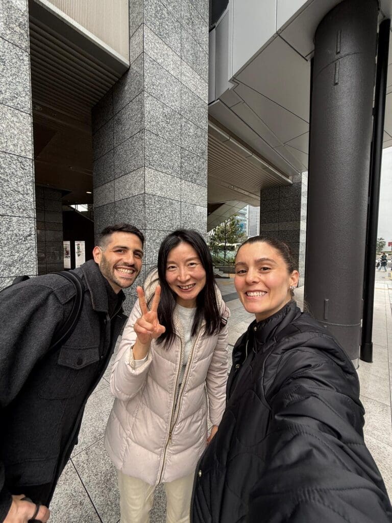 whatsapp-image-2025-07-15-at-10-26-48-am Three individuals posing for a selfie outdoors, with one making a peace sign and smiling.