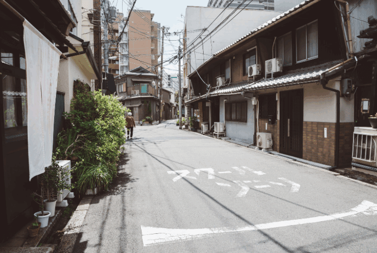 Hidden gems in Osaka, Narrow street in an urban area with traditional buildings and power lines overhead.
