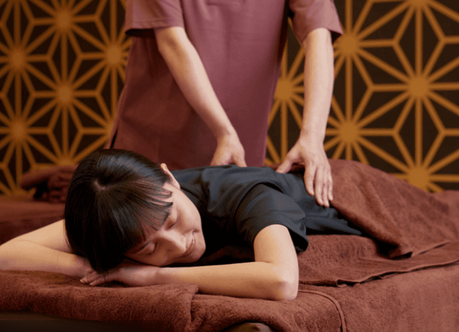 12 Best Massage in Osaka Experiences for Relaxation and Wellness 2 A person receiving a massage on a treatment table with a therapist applying pressure on their back.